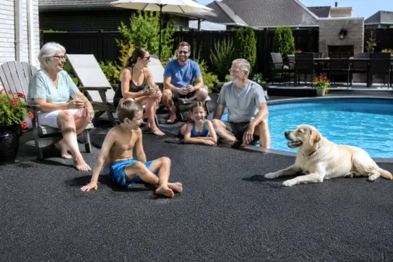 Kids and a dog playing safely on a rubber paved pool deck