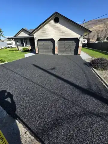 Same Kamloops driveway after rubber paving resurface — smooth black finish